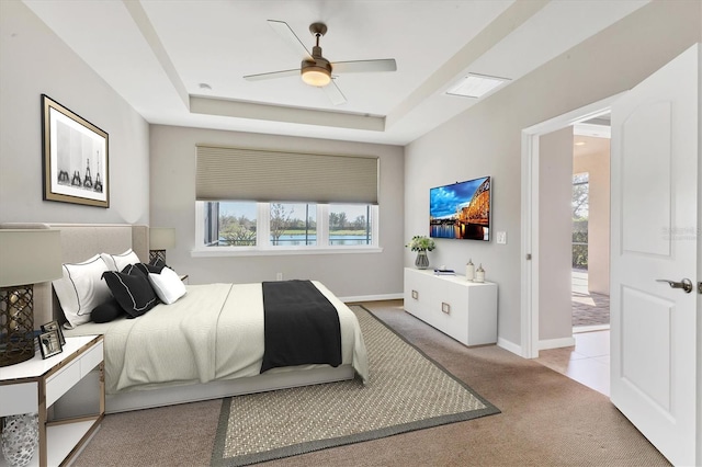 bedroom featuring carpet floors, ceiling fan, baseboards, and a raised ceiling