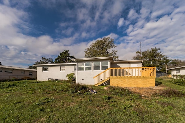 rear view of house with a yard and a wooden deck