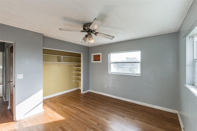 unfurnished bedroom featuring ceiling fan, a closet, and wood-type flooring