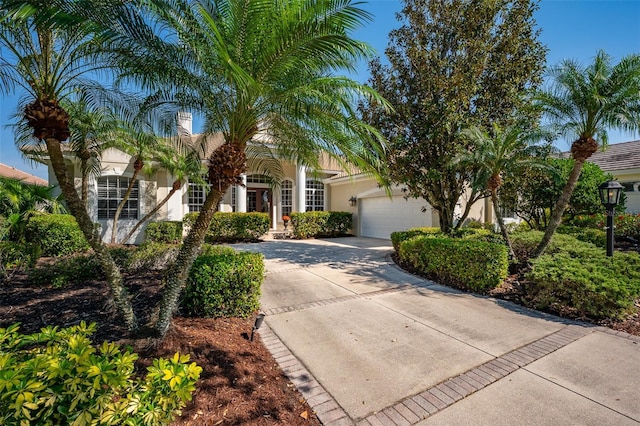 view of front of property with a garage, driveway, and stucco siding