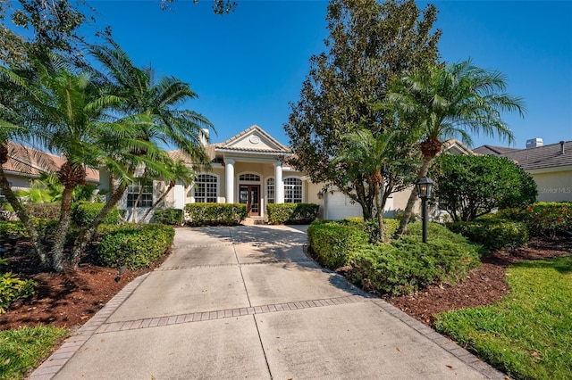 view of front facade featuring french doors, stucco siding, concrete driveway, a garage, and a tiled roof