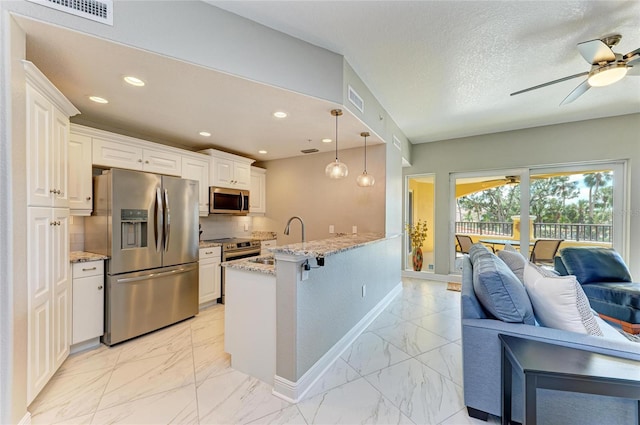 kitchen with marble finish floor, stainless steel appliances, a peninsula, and a sink