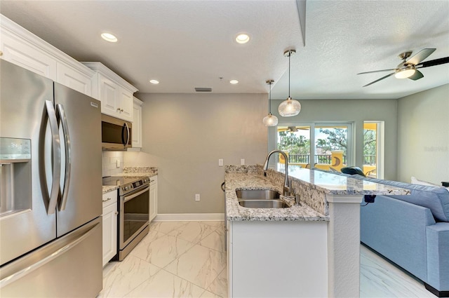 kitchen featuring marble finish floor, stainless steel appliances, white cabinetry, a sink, and a peninsula