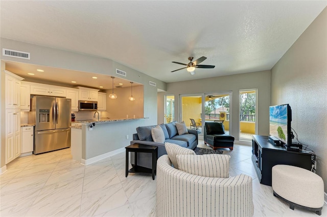 living area with marble finish floor, visible vents, and recessed lighting