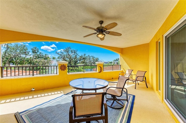 exterior space featuring a ceiling fan and a balcony