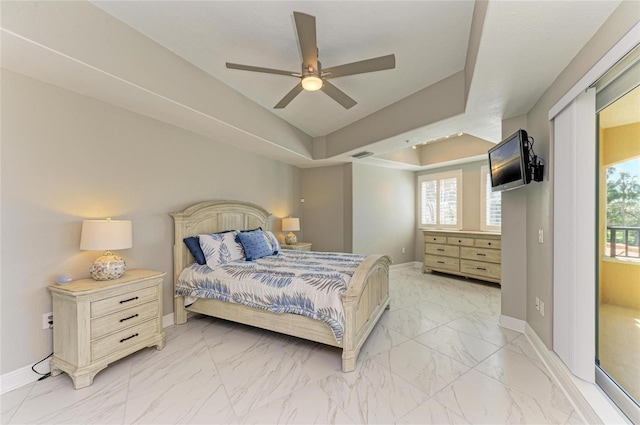 bedroom featuring marble finish floor, baseboards, and a raised ceiling