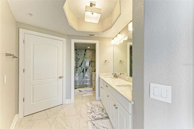 bathroom featuring a sink, baseboards, marble finish floor, double vanity, and a raised ceiling