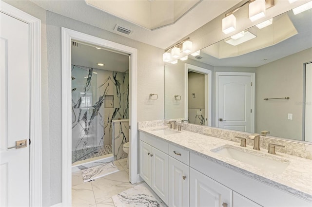 bathroom with marble finish floor, a marble finish shower, a sink, and toilet