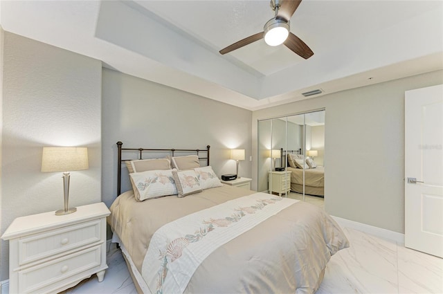 bedroom with visible vents, baseboards, marble finish floor, a closet, and a raised ceiling