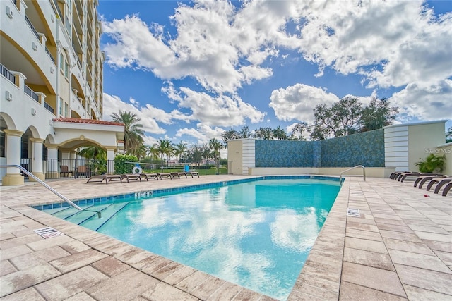 community pool featuring a patio area and fence