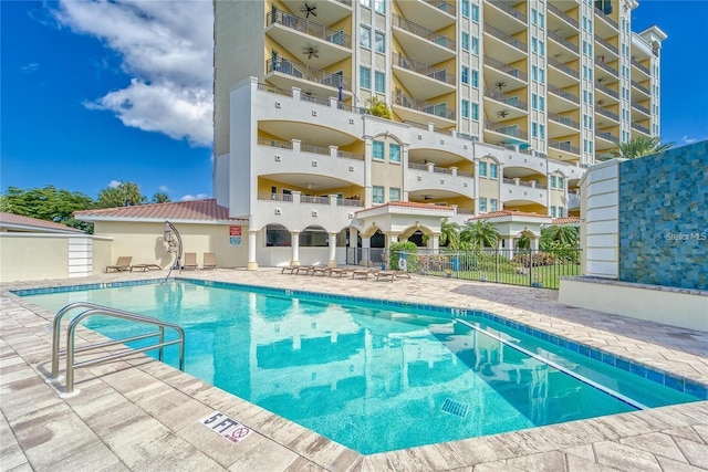 community pool featuring a patio area and fence