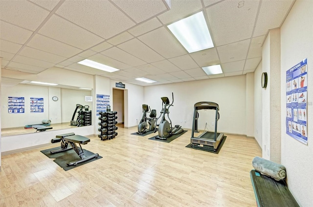 workout room featuring a drop ceiling and wood finished floors