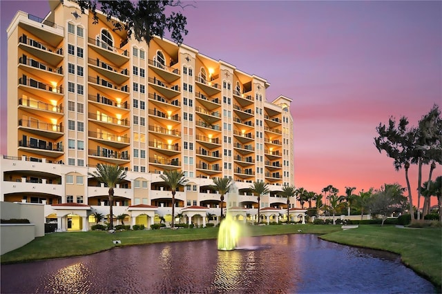 property at dusk featuring a water view