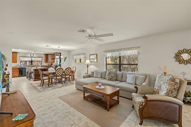 living room featuring light tile patterned floors, ceiling fan, and plenty of natural light