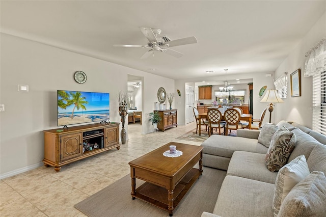 living room featuring ceiling fan with notable chandelier and light tile patterned floors