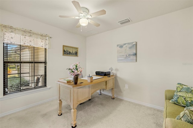 carpeted home office featuring ceiling fan