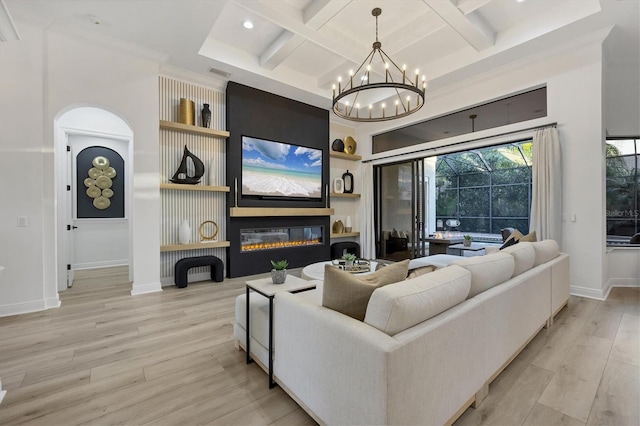 living room with built in features, light wood-style floors, a glass covered fireplace, coffered ceiling, and baseboards