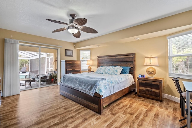 bedroom featuring light wood-type flooring, access to exterior, and multiple windows