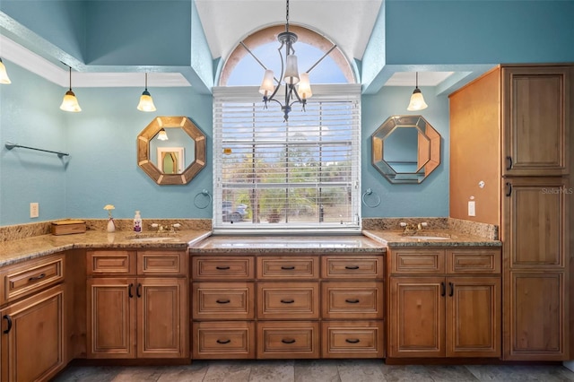 bathroom featuring a notable chandelier, a sink, and double vanity