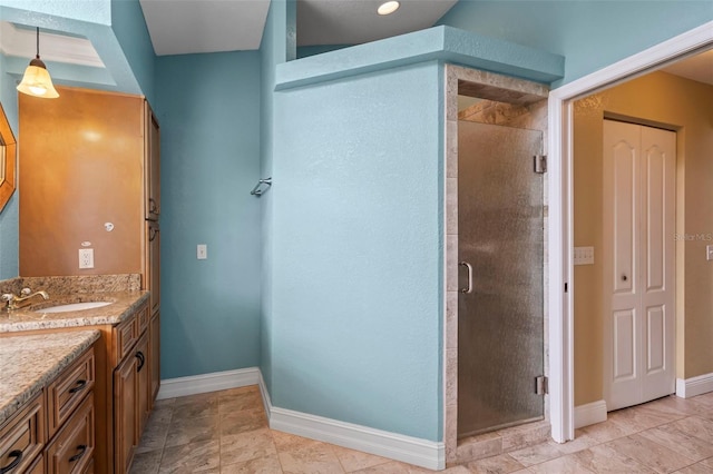 bathroom featuring a shower stall, baseboards, a closet, and vanity