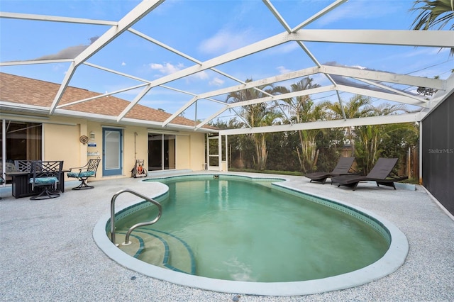 outdoor pool with glass enclosure and a patio