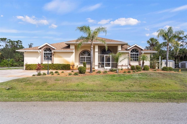 17368 Norseman Ave, Port Charlotte, FL 33948 - view of front of house featuring a storage shed, stucco siding, a front lawn, concrete driveway, and an outdoor structure