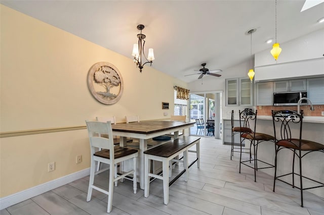 17368 Norseman Ave, Port Charlotte, FL 33948 - dining space featuring baseboards, vaulted ceiling, light wood finished floors, and ceiling fan with notable chandelier