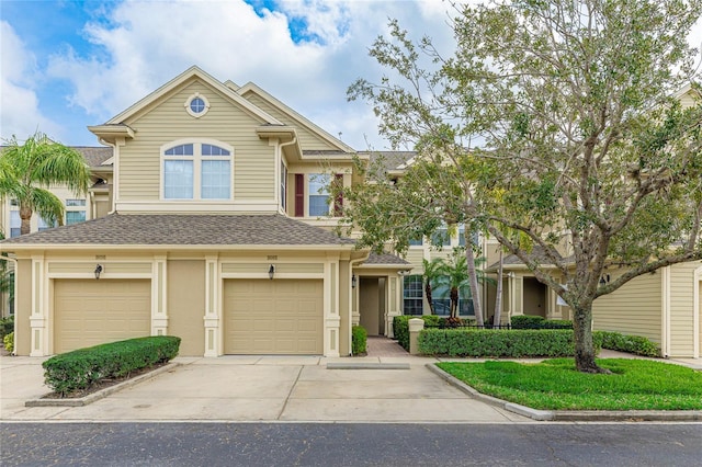 view of front of house featuring driveway, roof with shingles, an attached garage, and stucco siding