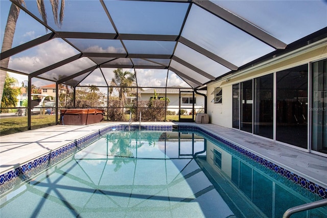 view of pool featuring a hot tub, a patio, and glass enclosure