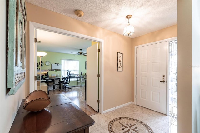 entryway with baseboards and a textured ceiling