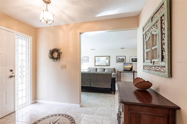 entryway featuring a textured ceiling and baseboards