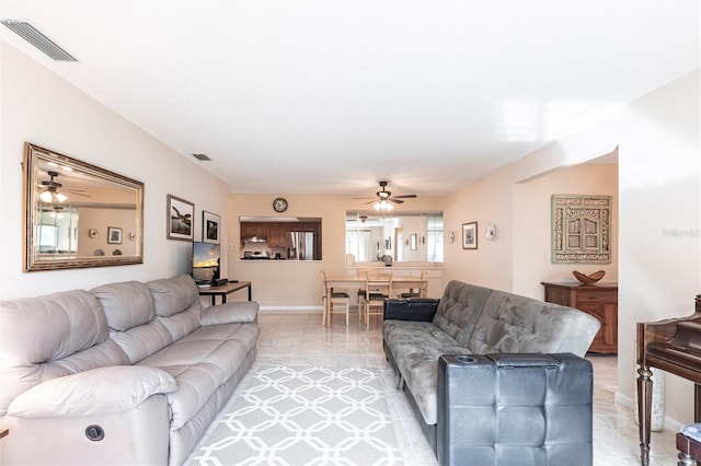 living room with baseboards, visible vents, a ceiling fan, and light tile patterned flooring