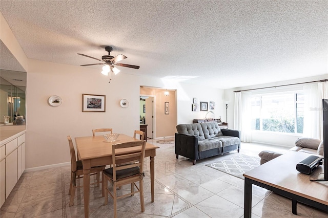 dining room featuring a ceiling fan, marble finish floor, a textured ceiling, and baseboards