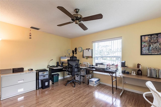 office area with visible vents, a textured ceiling, and wood finished floors