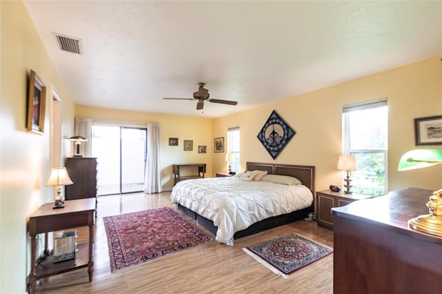 bedroom with light wood finished floors, ceiling fan, and visible vents