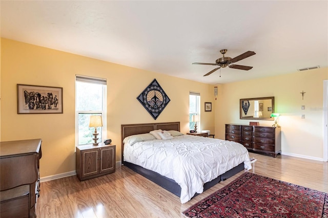 bedroom featuring light wood finished floors, multiple windows, and visible vents