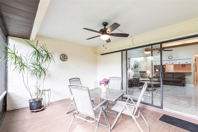 sunroom / solarium featuring a ceiling fan