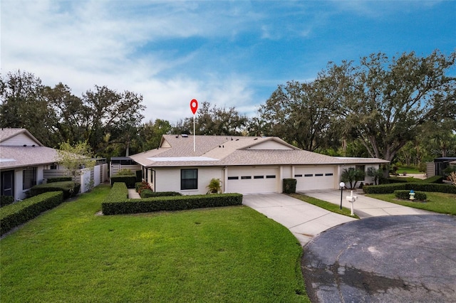 ranch-style house featuring driveway, roof with shingles, an attached garage, and a front yard