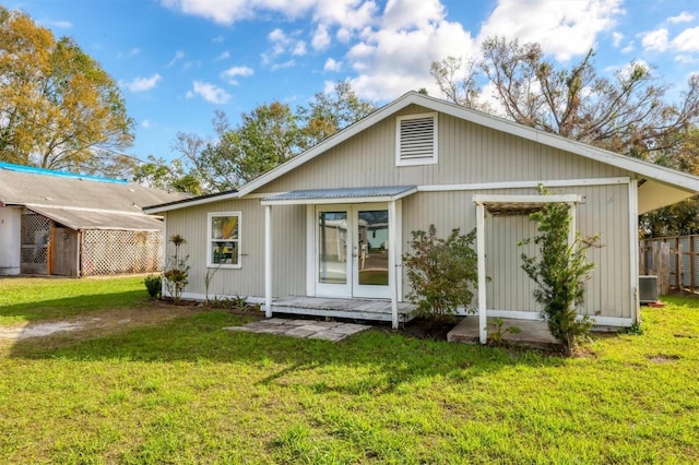 view of front of property with cooling unit, french doors, and a front lawn