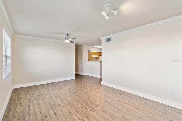 unfurnished room with crown molding, visible vents, light wood-style flooring, ceiling fan, and baseboards