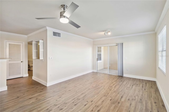 spare room with baseboards, light wood-style flooring, visible vents, and crown molding