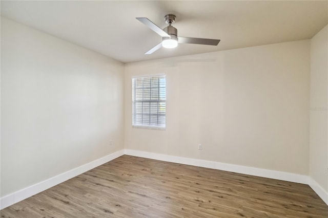 spare room featuring light wood-style floors, baseboards, and a ceiling fan