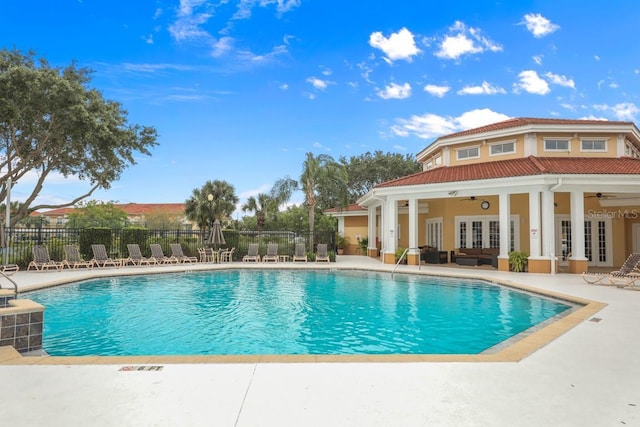 community pool featuring a patio area, ceiling fan, fence, and french doors