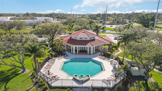 community pool with a fenced backyard and a patio