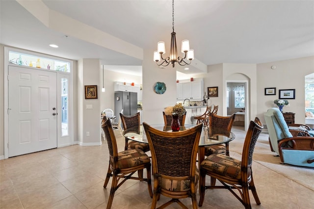 dining room featuring baseboards, recessed lighting, arched walkways, an inviting chandelier, and light tile patterned flooring