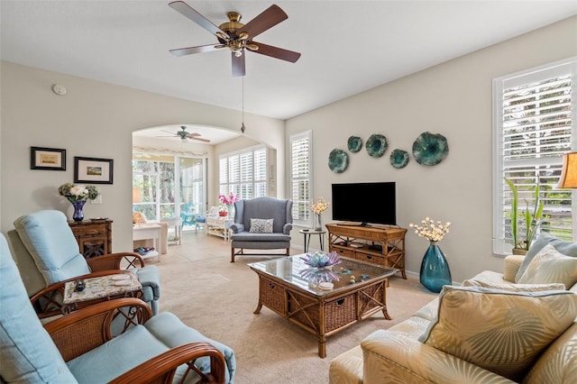 living area with light colored carpet and a ceiling fan