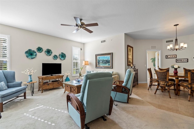 living room featuring light tile patterned floors, visible vents, light carpet, and ceiling fan with notable chandelier