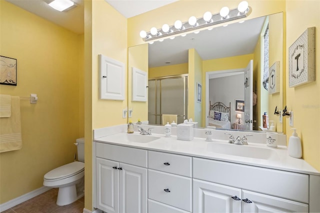 bathroom featuring double vanity, a stall shower, a sink, tile patterned floors, and toilet