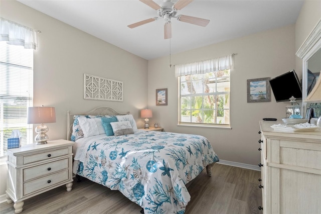 bedroom with a ceiling fan, wood finished floors, and baseboards