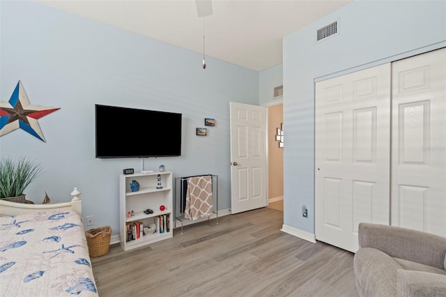 bedroom with light wood-style floors, visible vents, a closet, and baseboards